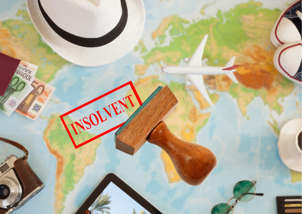 Ein Stempel mit der Aufschrift "INSOLVENT" liegt auf einer Weltkarte, umgeben von Reiseutensilien wie einem Hut, Geldscheinen, einem Spielzeugflugzeug und einer Kamera. Das Bild symbolisiert die Insolvenz des Reiseveranstalters FTI und BigXtra, die beide zur FTI Group gehören.